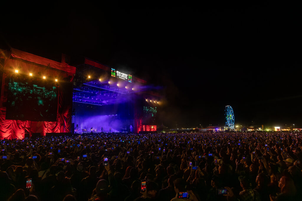 Público frente al escenario iluminado de Tecate Comuna por la noche